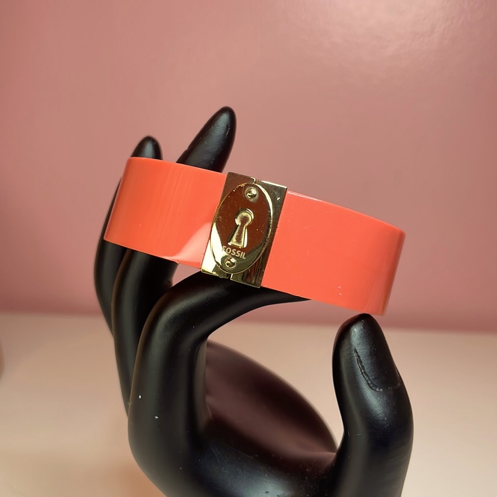 Fossil pinkish salmon colored hard plastic and gold tone bangle/cuff bracelet